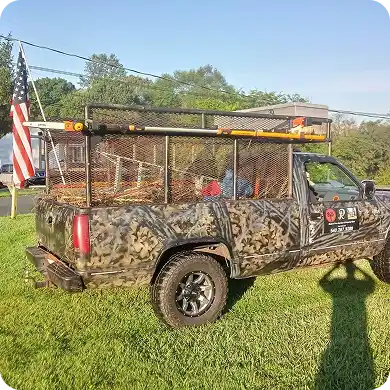 Tree service work truck with a camouflage design, loaded with brush.